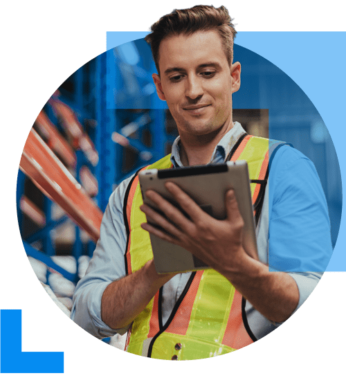 A man in work attire uses a clipboard to oversee logistical oporations within a warehouse, representing the Distribution and Logistics sector.