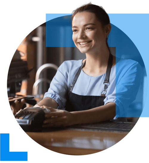 A friendly cashier presents a card machine at a counter in a retail setting, symbolising the Retail sector.