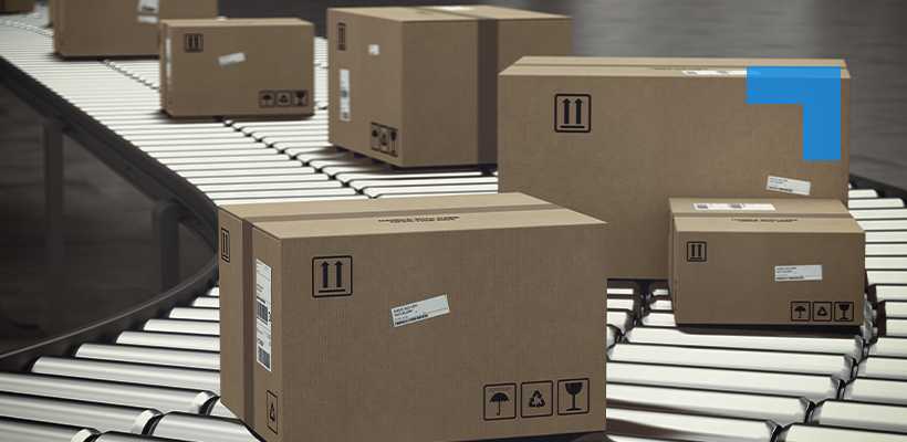 Cardboard shipping boxes of various sizes moving along a curved conveyor belt in a warehouse distribution centre.